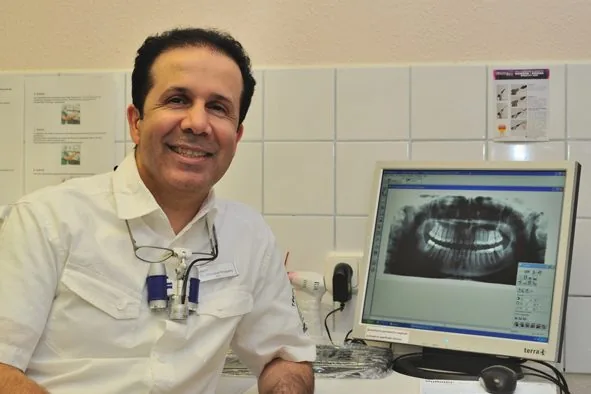 Zahnarzt Dr. M. Khayami am Bildschirm mit einer Röntgenaufnahme